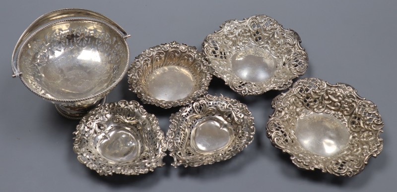 A George V silver pedestal bonbon basket and six other small silver dishes including set of three and a matched pair.